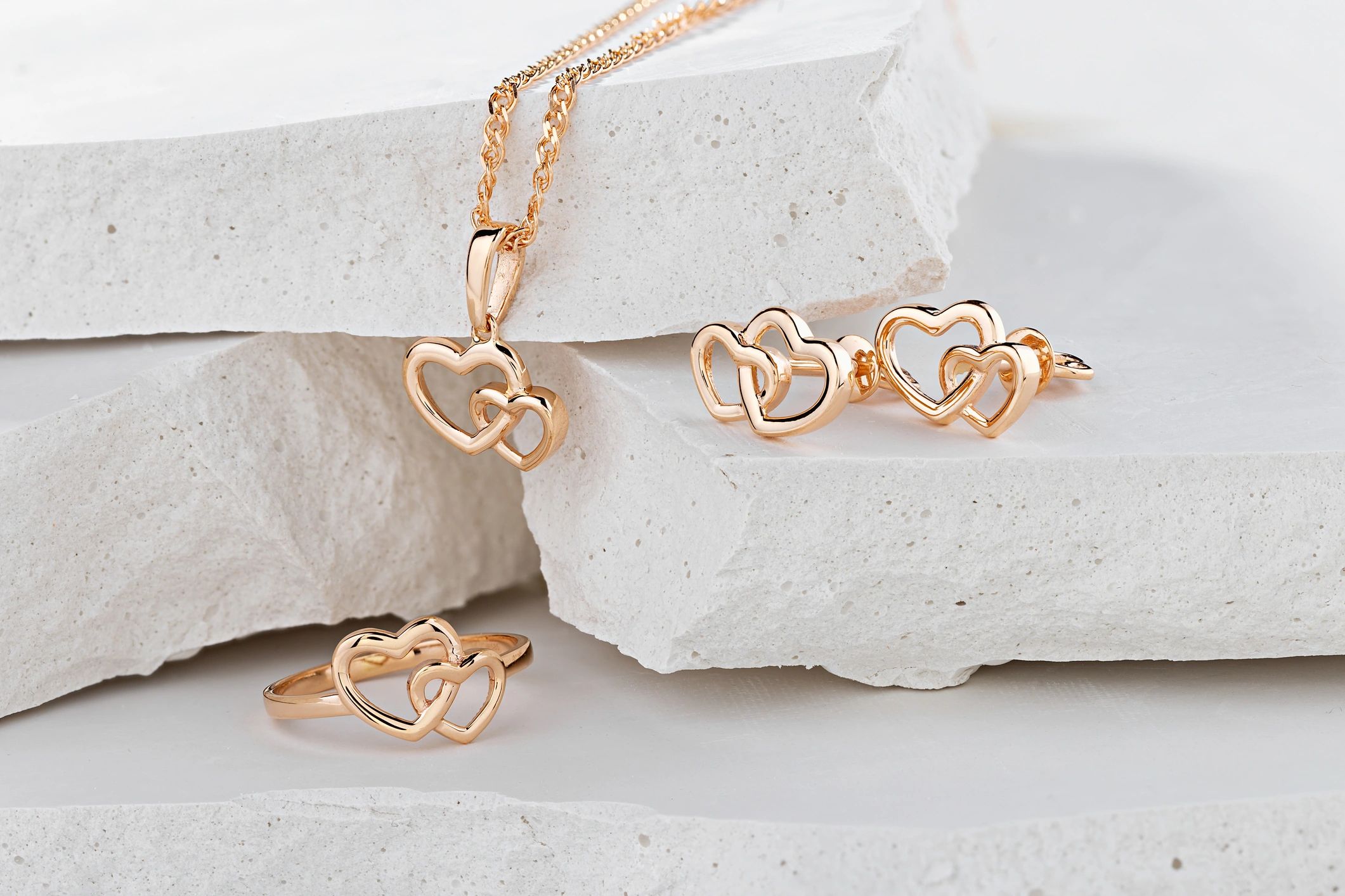 Rose gold heart jewelry set on white background