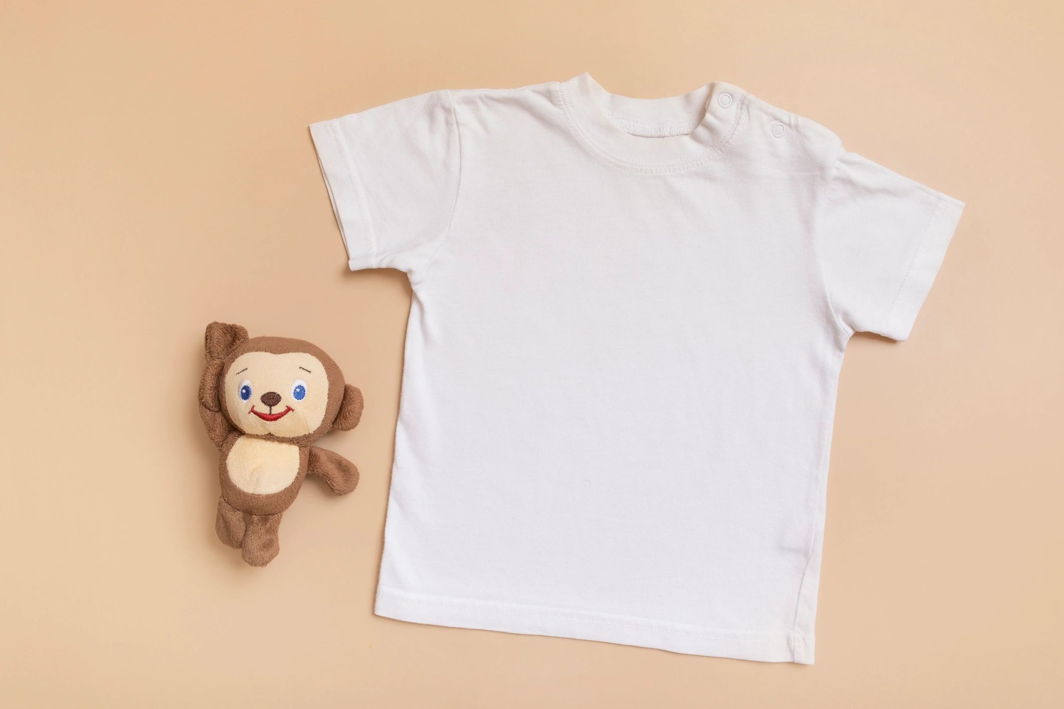 Baby t-shirt flat lay on beige background