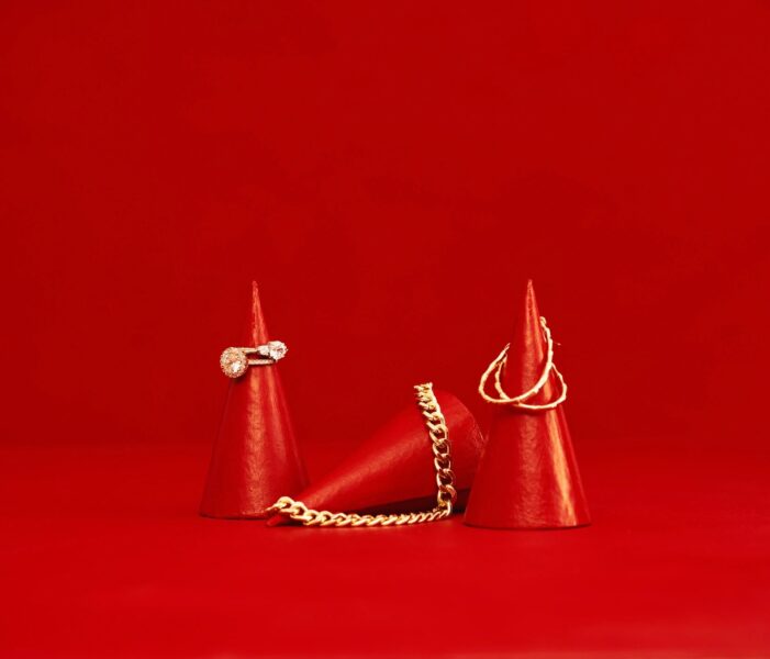 Collection of women's jewelry on red cone displays. Red background with space for copy