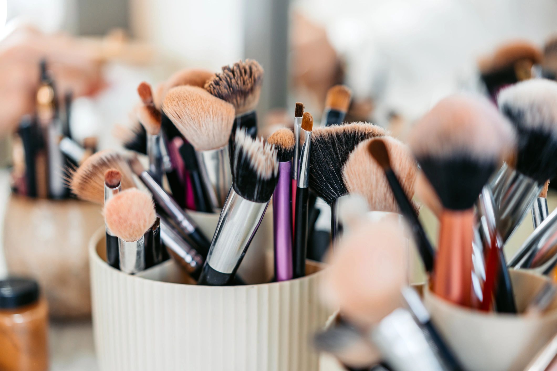 Makeup brushes and beauty products arranged on a desk