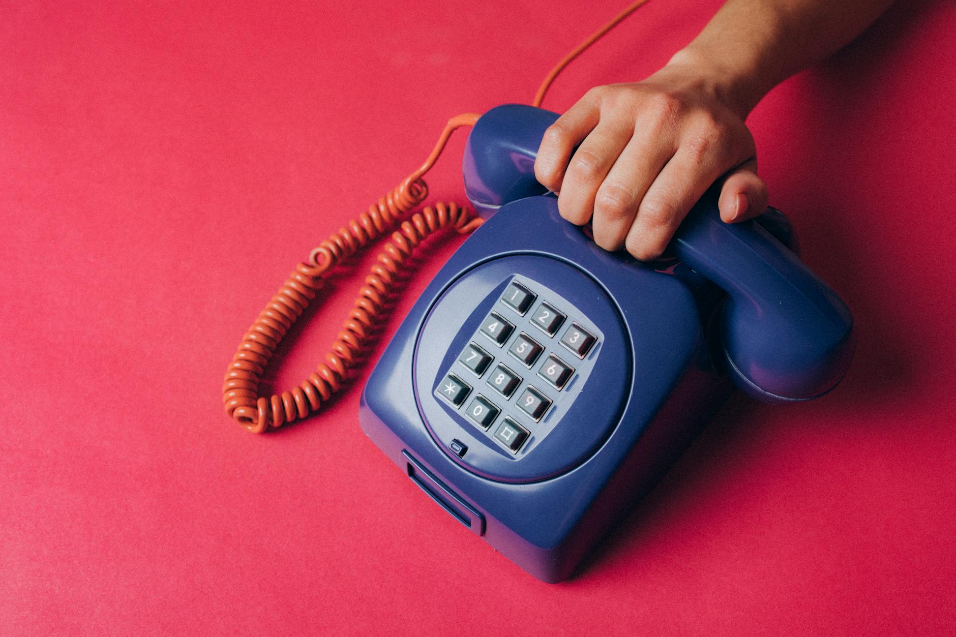person holding an old corded telephone